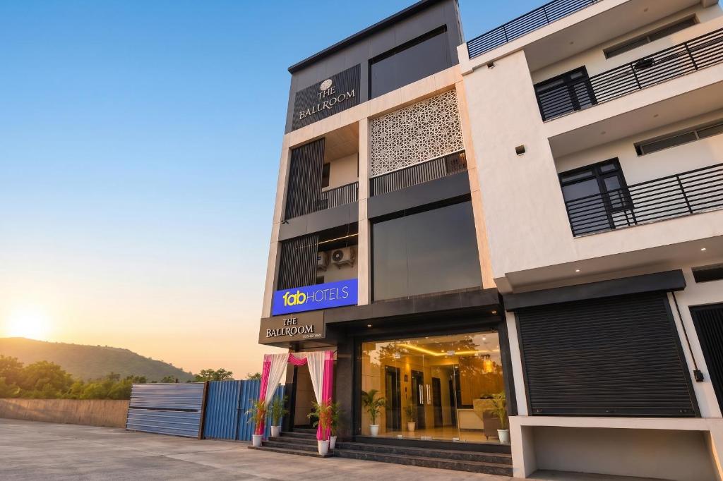 a building with a store front with the sunset in the background at FabHotel Prime The Ballroom - Near GD Goenka University in Gurgaon