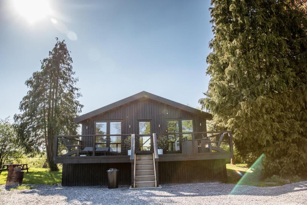 a small cabin with a staircase in front of a tree at The Larch House in Chester