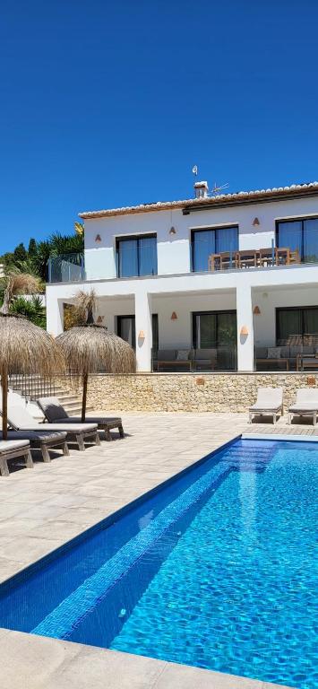 a villa with a swimming pool next to a building at The Villa by Los Limoneros in Teulada
