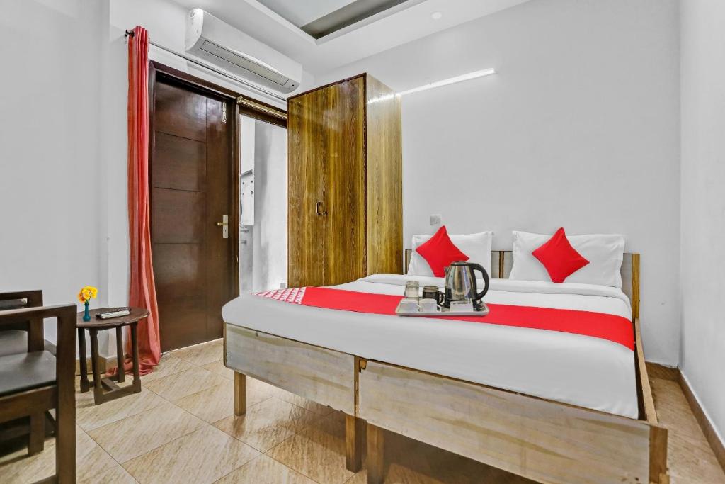 a bedroom with a large bed with red pillows at Hotel O Premium Inn in New Delhi