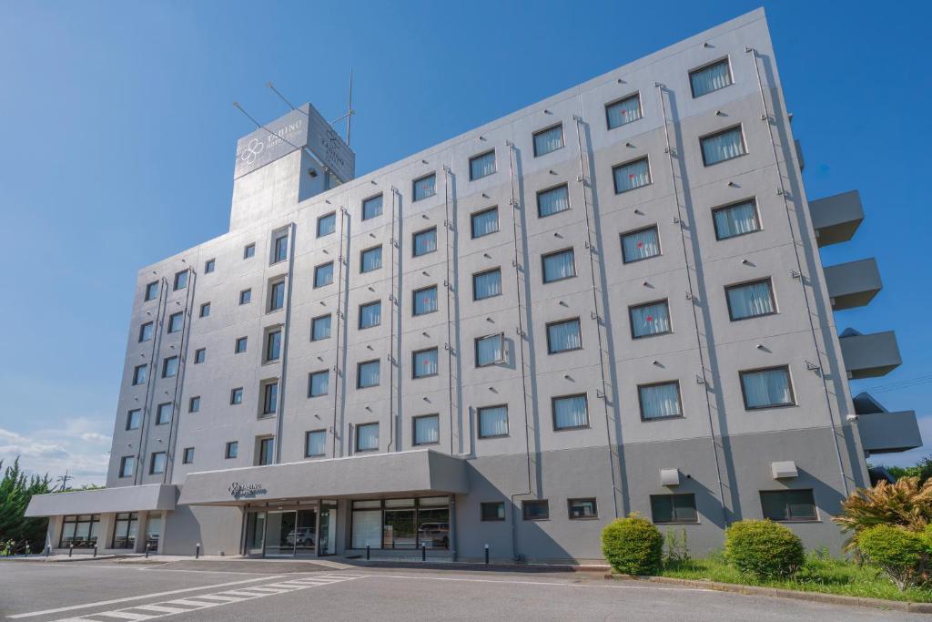 a large white building on the side of a street at Tabino Hotel EXpress Narita in Narita