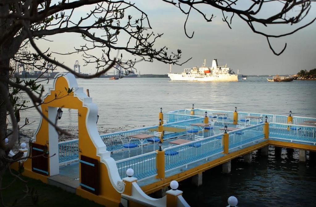 a dock with a cruise ship in the water at Bloom Boutique Waterfront Fort Kochi in Cochin