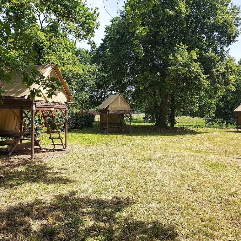 a group of tents in a field with trees at Camping Onlycamp Veuzain-sur-Loire in Veuzain-sur-Loire
