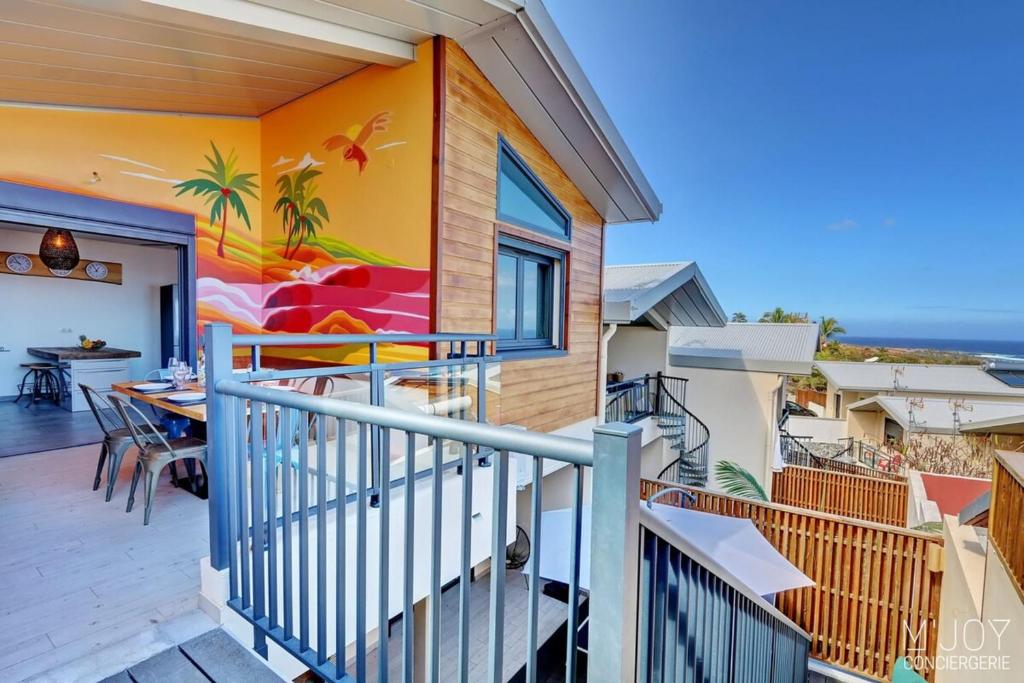 a house with a balcony with a table and chairs at PAPANG - House 148m 3rooms Jacuzzi in Saint-Leu