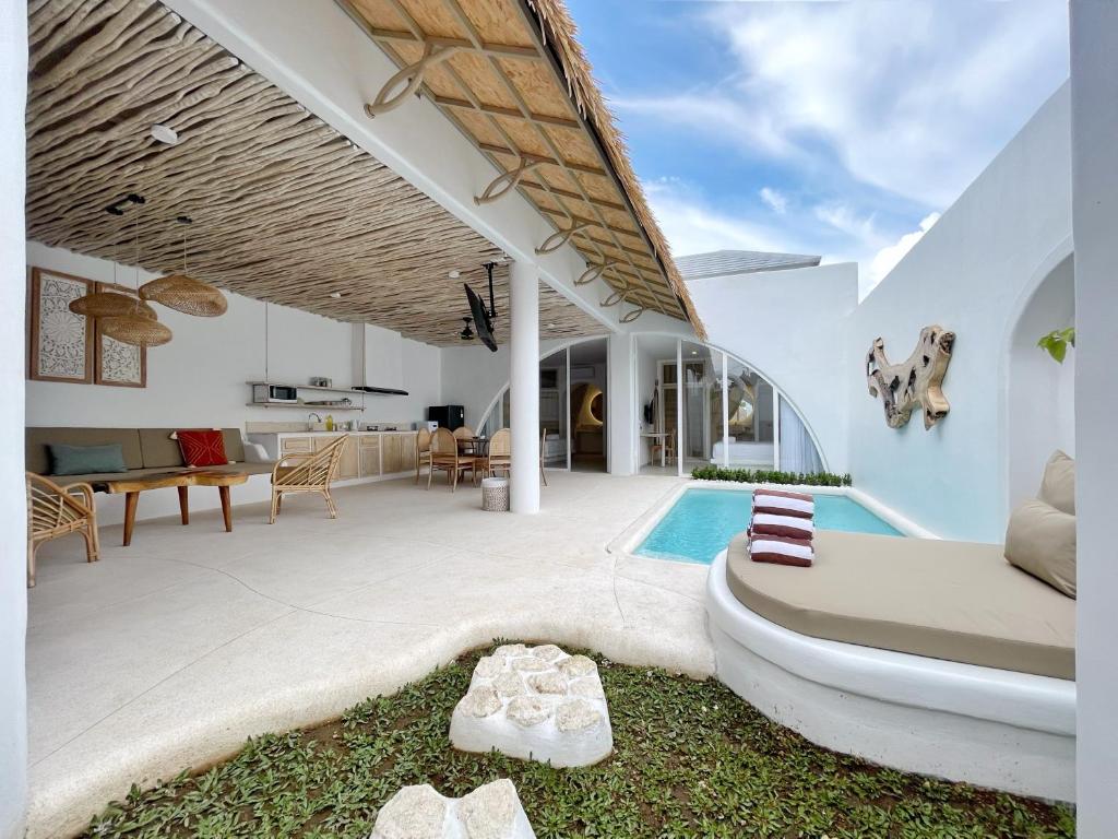 an outdoor living room with a swimming pool and a house at Villa Sei Uluwatu by LODGELINK BALI in Uluwatu
