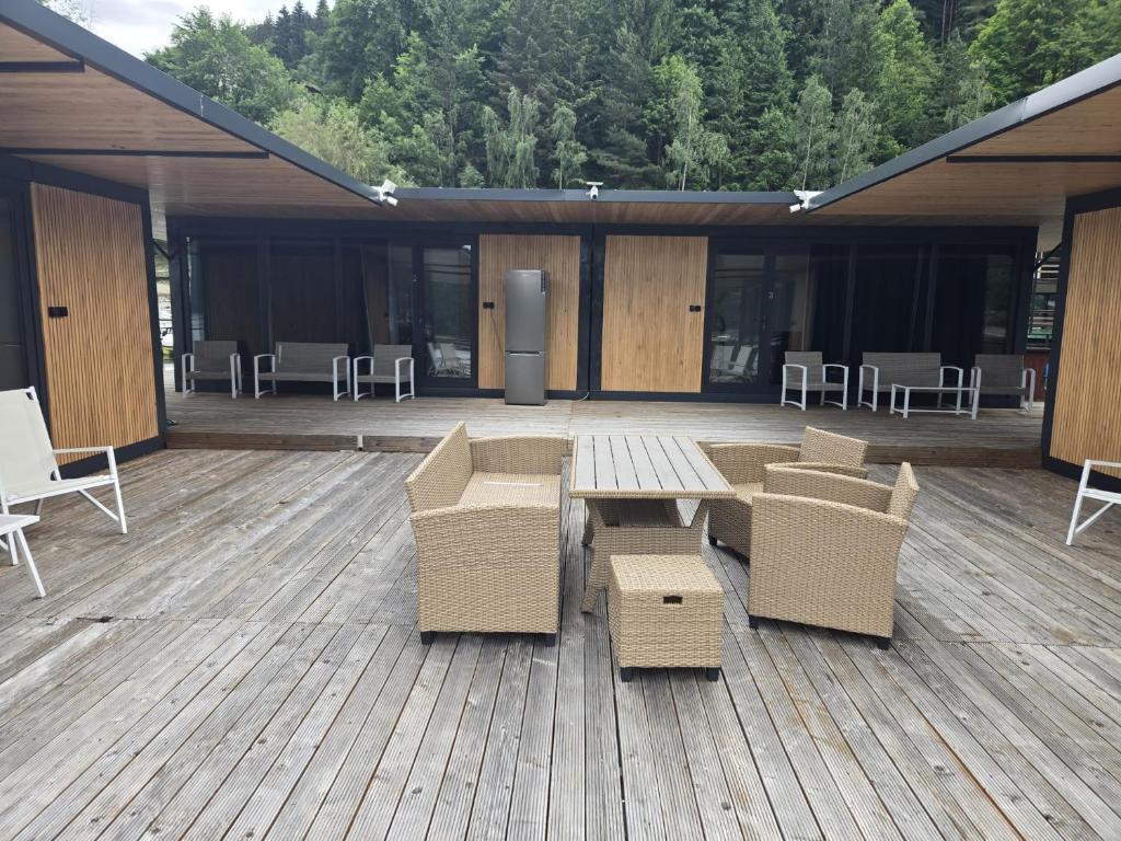 a patio with a table and chairs on a wooden deck at Ponton Plutitor New Life in Bicaz