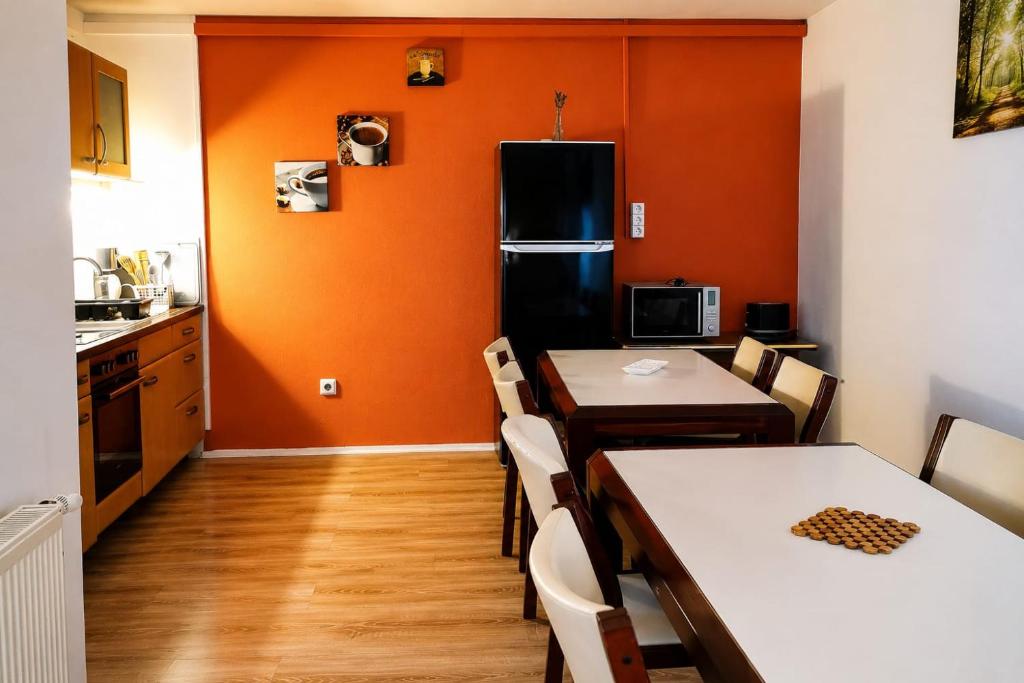 a kitchen with two tables and a black refrigerator at Naab-burg in Nabburg