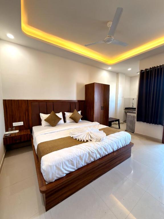 a bedroom with a large bed with a wooden headboard at Hotel Shree Krishnam, Kota in Kota