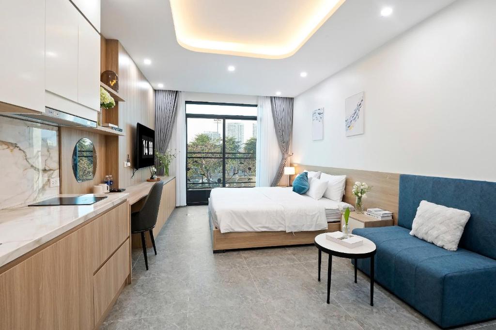 a hotel room with a bed and a blue couch at Hanoi Cosmos Hotel in Hanoi