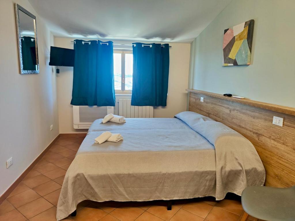 a bedroom with a large bed with blue curtains at La Casa di Stefy - affittacamere in Cammarata
