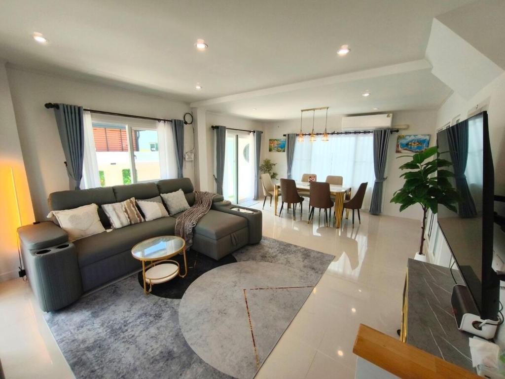 a living room with a couch and a dining room at Silbergluuk in Udon Thani