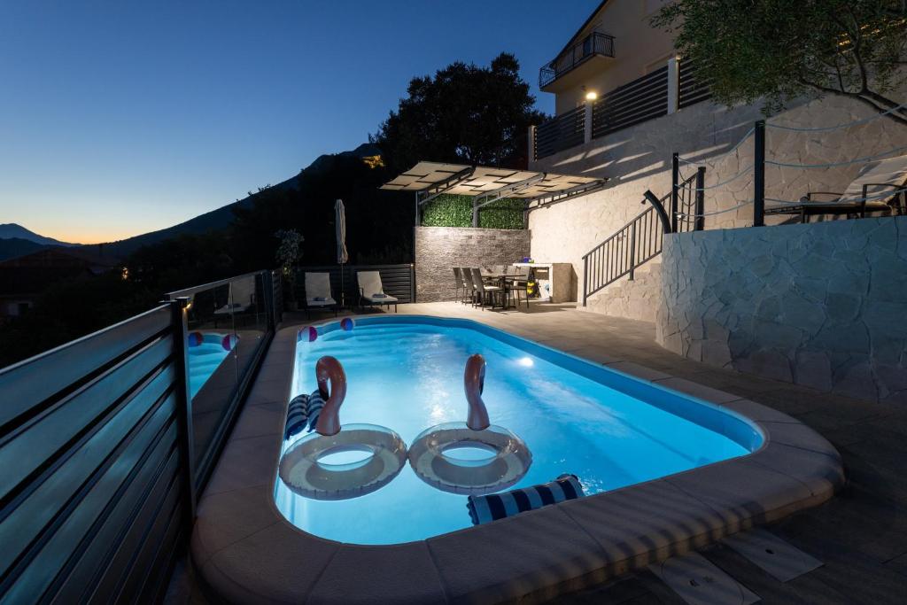 a swimming pool with two swans in the middle at Apartman Klara in Vrgorac