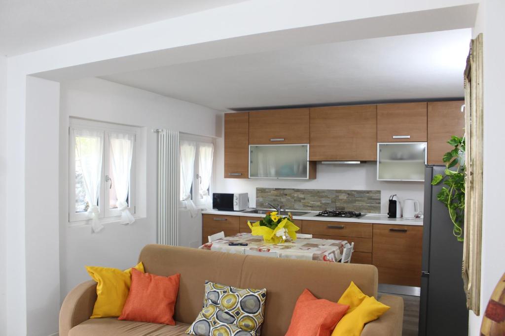 a living room with a couch and a kitchen at TAVANIs HOUSE in Delebio