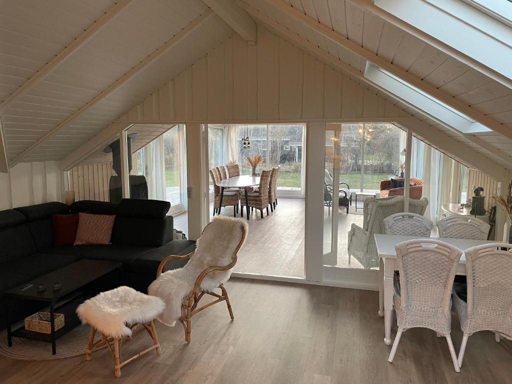 a living room with a couch and a table and chairs at Charming House Close To The Beach in Gedser