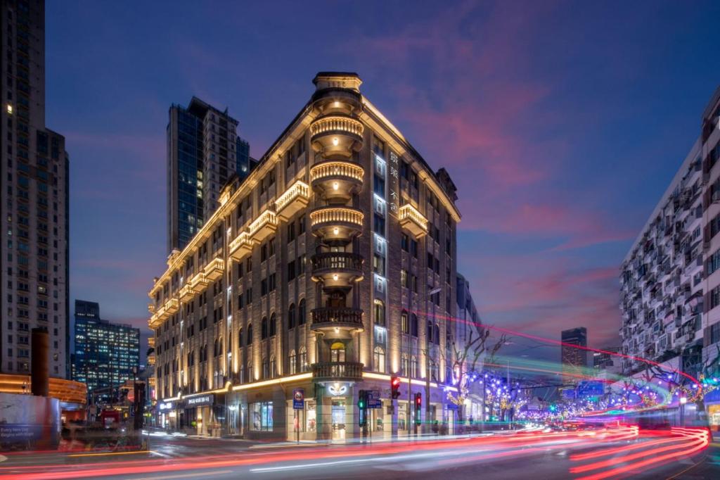a building on a city street at night with lights at JingLai Bushe Hotel the Bund Nanjing West Road Shanghai in Shanghai
