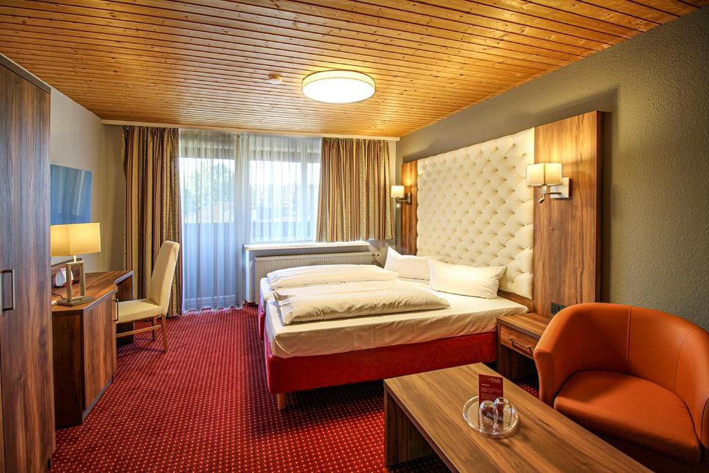 a hotel room with a bed and a chair at Morada Hotel Bad Wörishofen in Bad Wörishofen