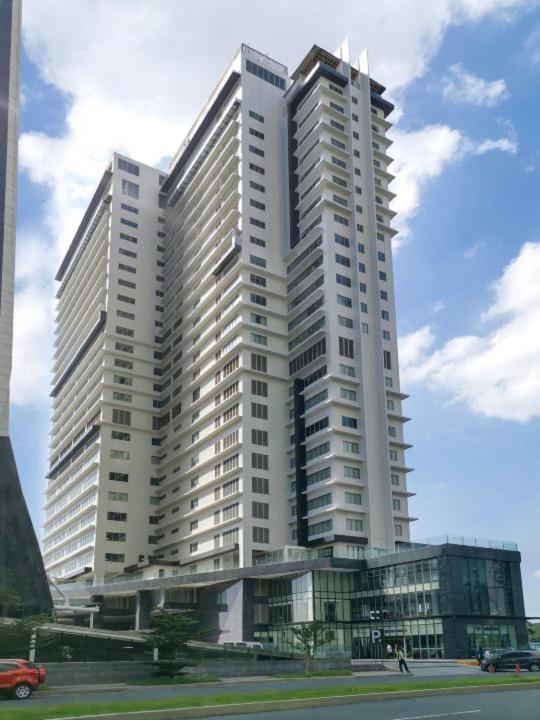 a large white building with a car in front of it at Brittany Hotel BGC in Manila