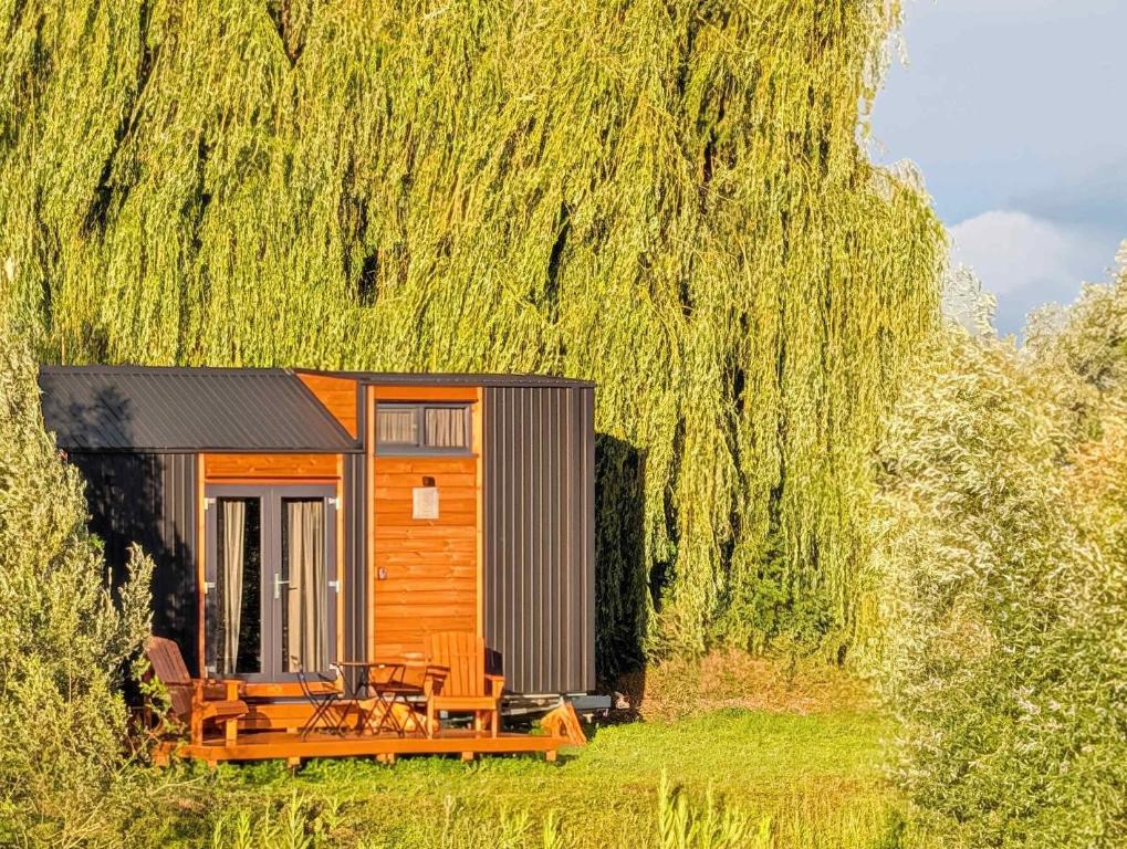 a small cabin in a field with a tree at Ezy House by Tiny Away in Ézy-sur-Eure