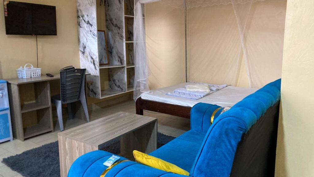 a room with a bed and a table and a couch at Margin Diani in Ukunda