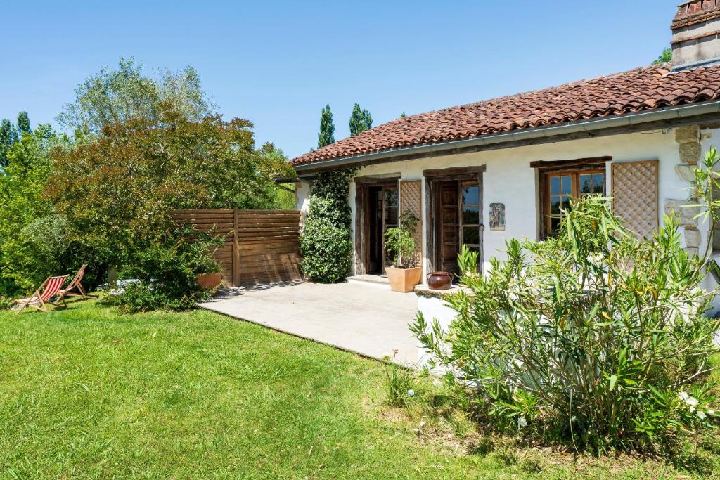 a small white house with a garden and a fence at Dependance avec Jacuzzi in Arcangues