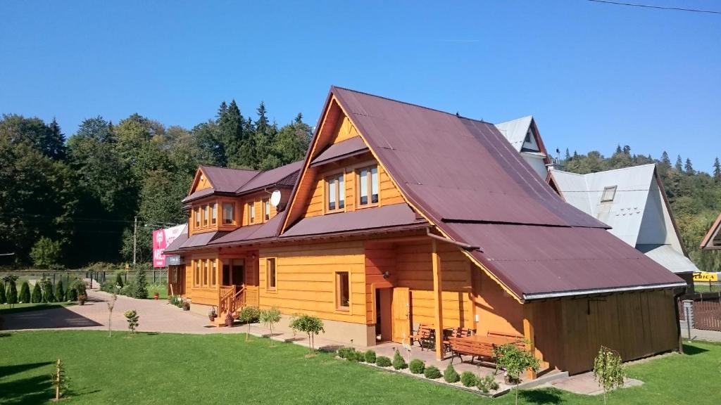 a large wooden house with a metal roof at Chałupka na szlaku Zacisze in Biały Dunajec