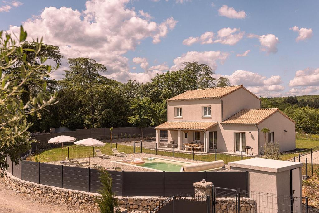 a house with a fence around a swimming pool at Villa des Roches - Labeaume in Labeaume