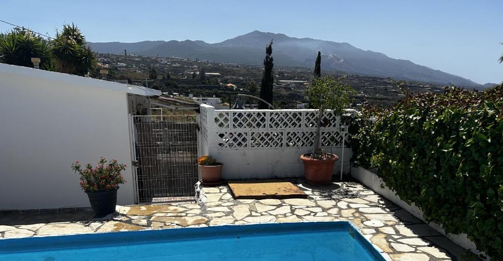 a swimming pool in a backyard with a white fence at Casitas Las Pereras in Los Llanos de Aridane
