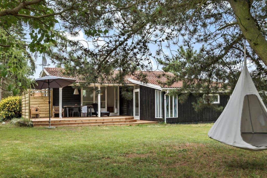 a house with a deck and an umbrella at 1102-Stege-Rylevej-24 in Stege