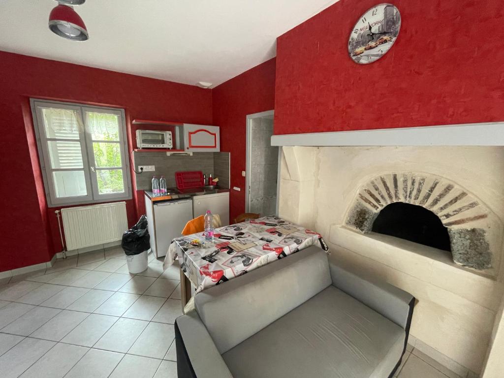 a red room with a bed and a fireplace at Chez KUD in Bourbon-Lancy