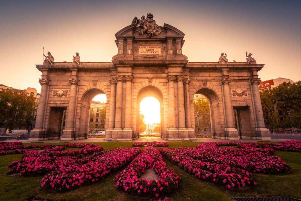 a large building with a bunch of pink flowers at Hostel LAS ROSAS in Madrid