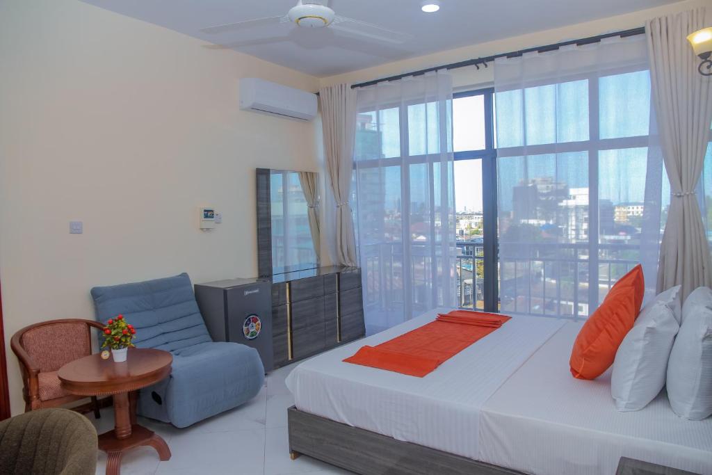 a bedroom with a bed and a large window at Andrew View Hotel in Dar es Salaam
