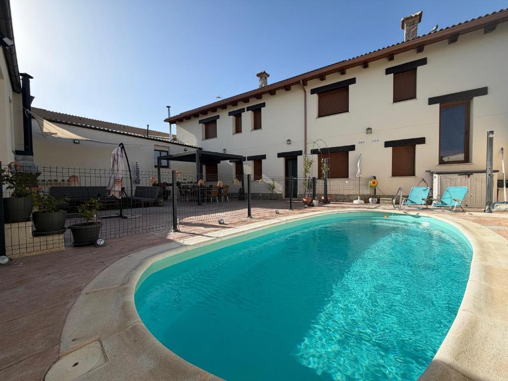 a swimming pool in front of a building at Casa Rural Villa Cárcavas in Maello