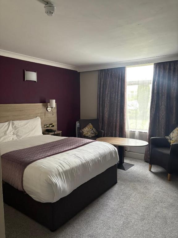 a hotel room with a bed and a table at Treacys West County Conference and Leisure Centre in Ennis