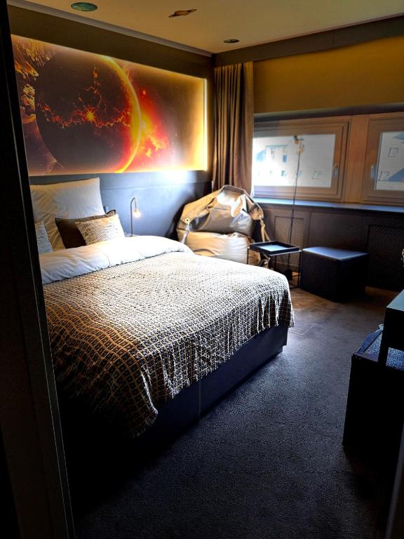 a hotel room with a bed and a painting on the wall at Sleephotels Cosmos in Hamburg