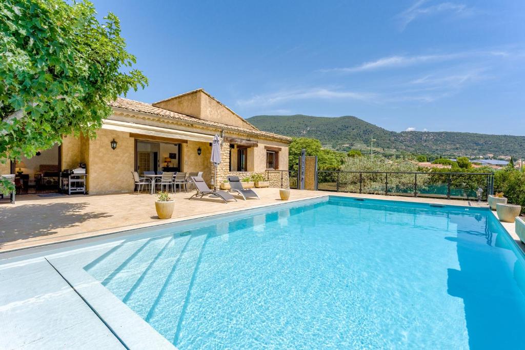a swimming pool in front of a house at La Villa D'antan - Piscine in Nyons
