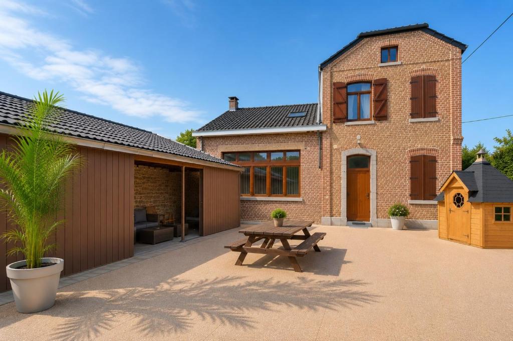 a brick house with a picnic table in front of it at Gite Familiale La Classe in Modave