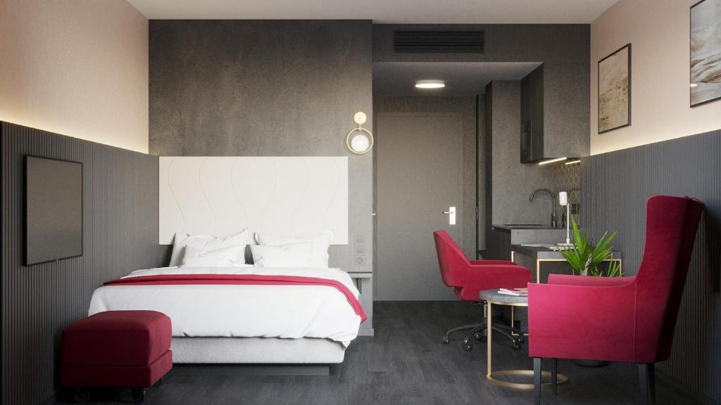 a bedroom with a bed and a desk and chairs at PLAZA Residence Mannheim in Mannheim