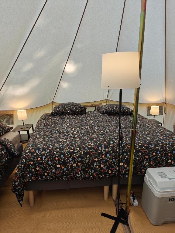 a bedroom with a bed in a tent at Camping and Gîtes - Le Mas d'Ayen in Ayen