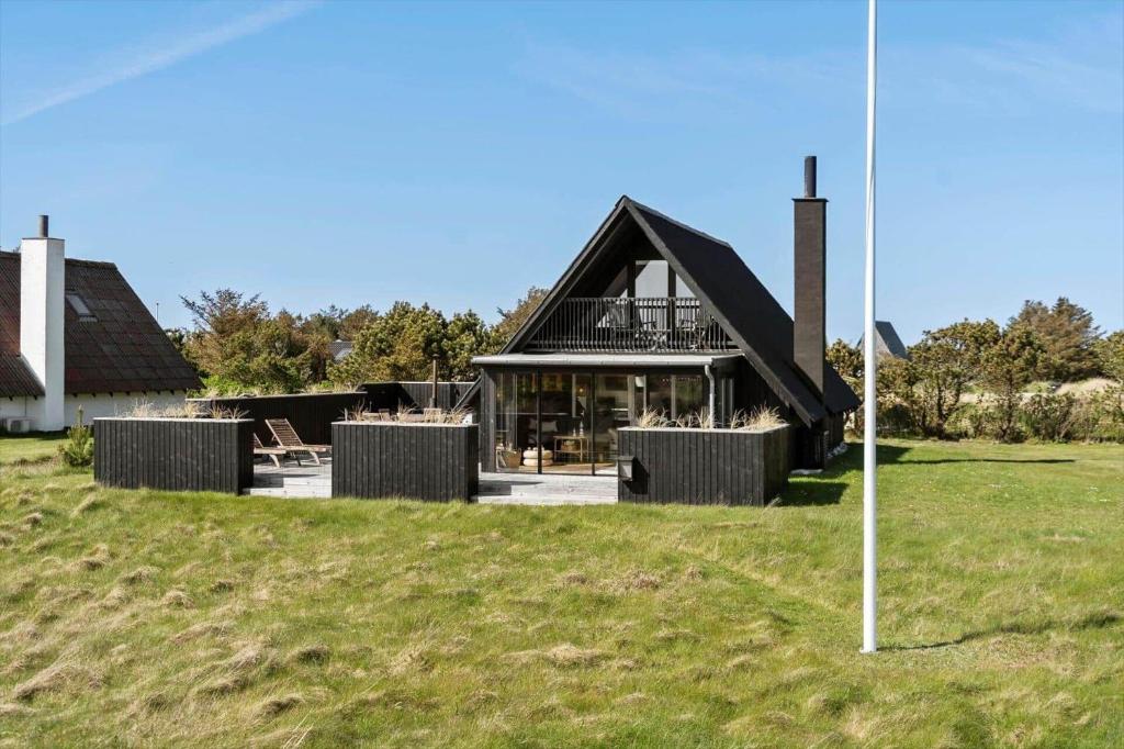 a house with a black roof on a green field at 1335-Vestervig-Spovevej-11 in Vestervig