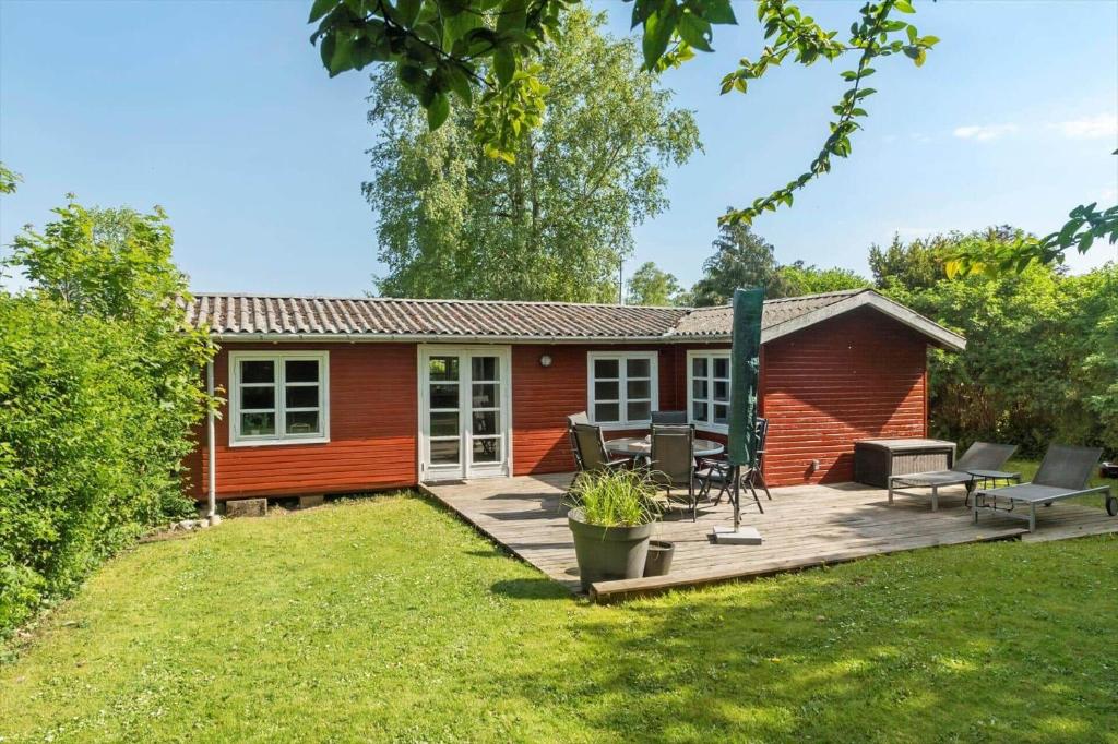 a red house with a deck and a patio at 3032-Stege-Ankeret-4 in Stege