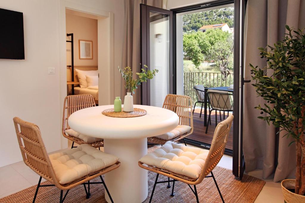 a dining room with a white table and chairs at Casa Serena Bol in Bol