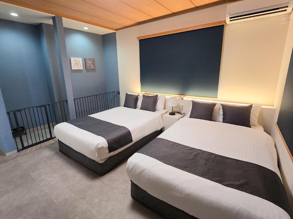 a hotel room with two beds and a large window at KUON Onomichi - クオン尾道 in Onomichi