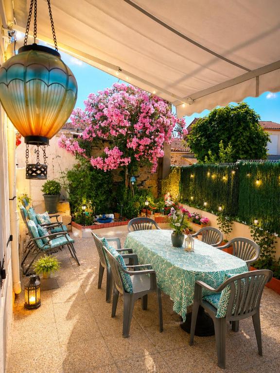 a patio with a table and chairs and pink flowers at Les aires in Tourbes
