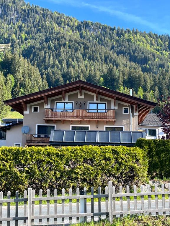 a house with a fence in front of a mountain at Ferienwohnung Wieser in Sankt Jakob in Haus
