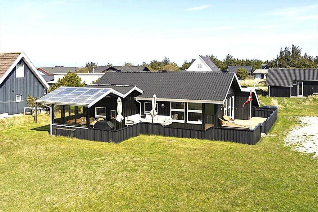 a black house with a solar roof on a grass field at 1369-Thisted-Nordsovej-94 in Nørre Vorupør