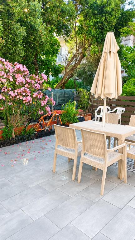 a table and chairs with a umbrella and flowers at Villa Maria in Ierissos