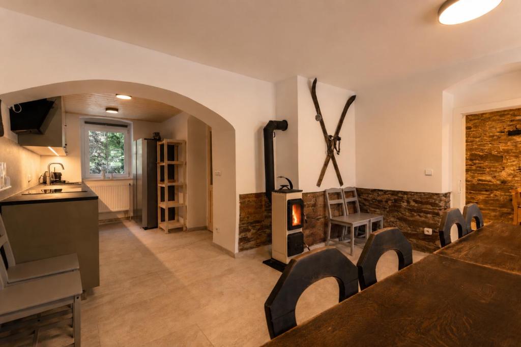a kitchen and living room with a fireplace at Chata Ve Stopě in Boží Dar