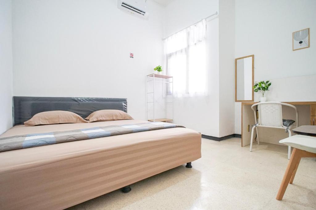a bedroom with a large bed and a desk at Omah Alamanda in Sleman