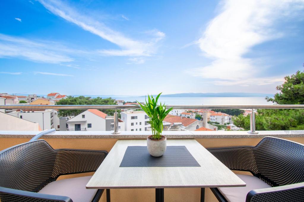 a table and chairs on a balcony with a view at Apartmani Eterović in Baška Voda