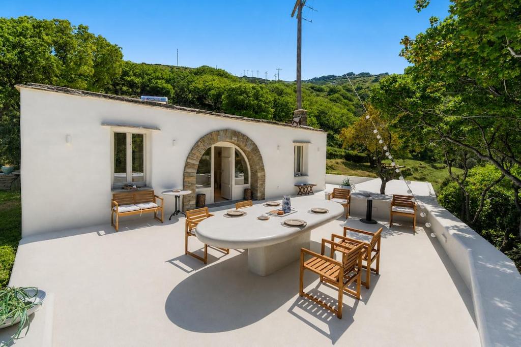 an outdoor patio with a table and chairs at Nest Gateway - Panoramic Mountain Views in Apoíkia